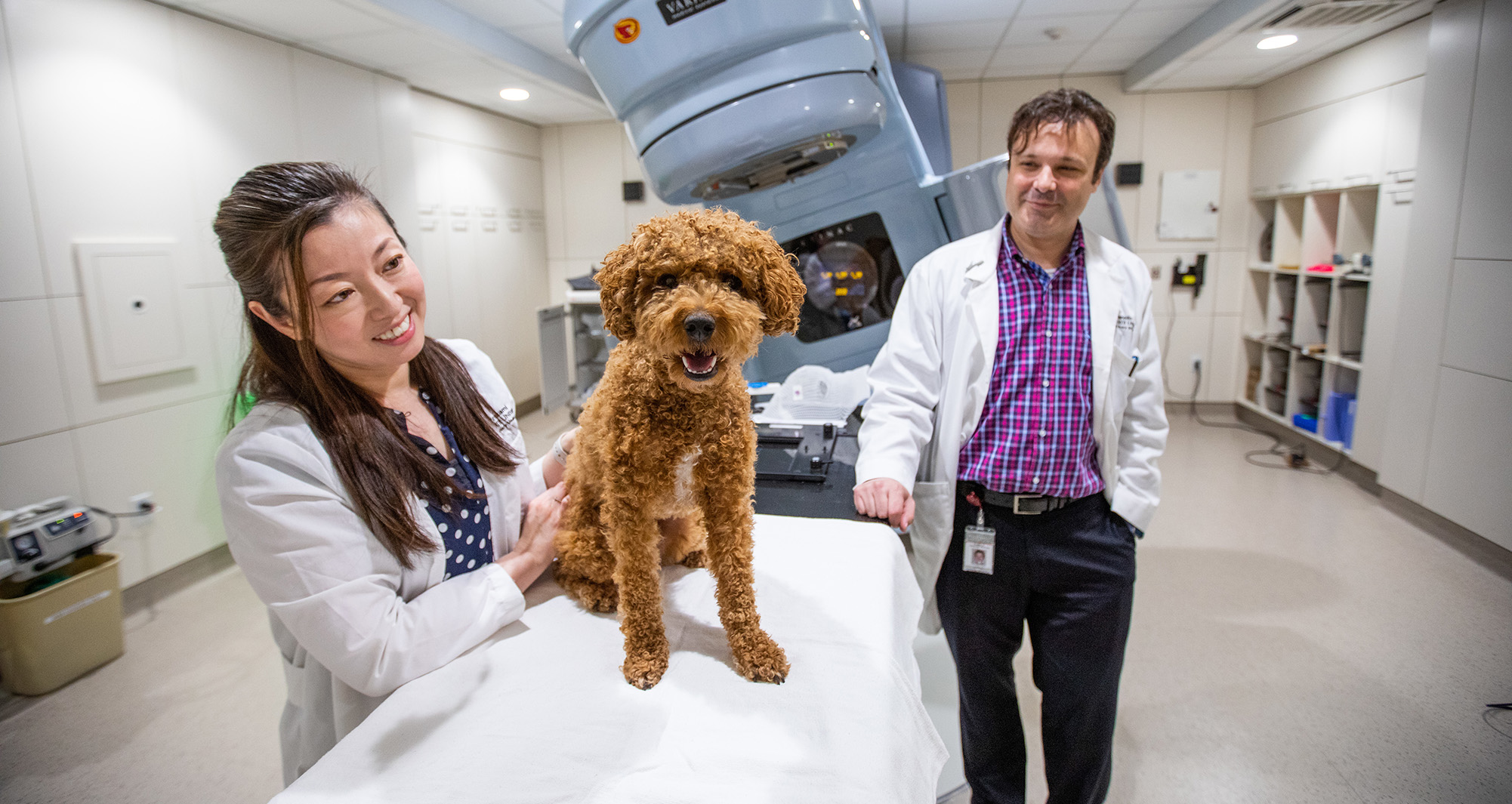 Drs. Murikami and Rancilio with dog in oncology suite