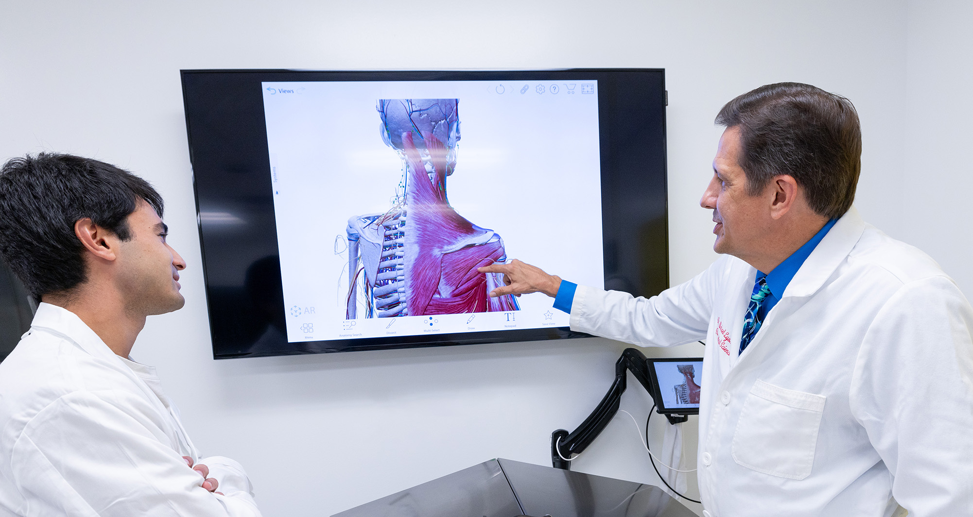 Biomedical student with professor examining figure on screen