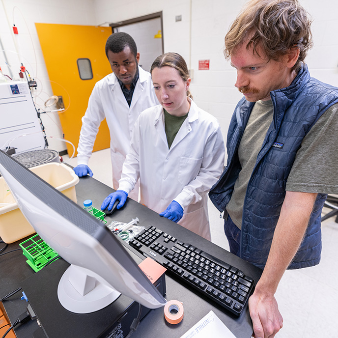 Biomedical sciences graduate students with professor in lab